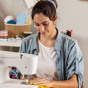Frau sitzt an der N&auml;hmaschine